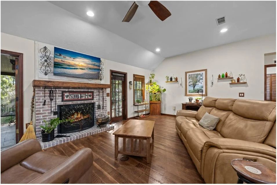 Vaulted living room with a brick fireplace in the ranch-style Gainesville property