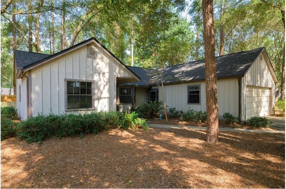 L-shaped ranch home among mature trees in Gainesville, exterior view