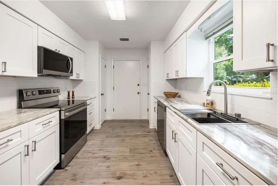 Renovated white shaker kitchen in the gray single-story Gainesville home